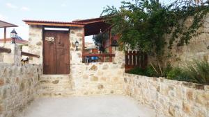 a stone house with a wooden door and a stone wall at Simona Stone House in Polis Chrysochous
