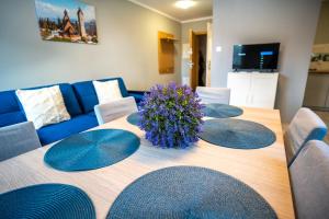 a table with four plates on it with a blue couch at Szafirowe Oczko in Karpacz