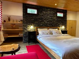 1 dormitorio con cama y pared de ladrillo en Mountain Chalet - Cabana la Muntele Baisorii en Muntele Cacovei