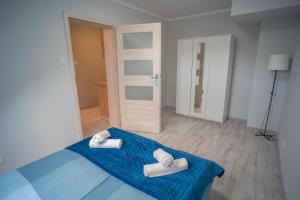 a room with a blue bed with two towels on it at Szafirowe Oczko in Karpacz