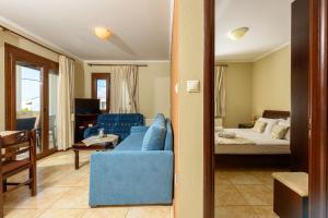 a living room with a blue couch and a bed at Villa Angel in Limenas