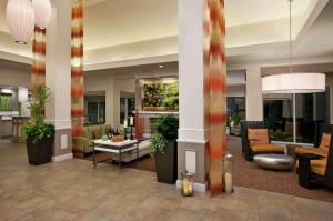 a lobby of a hotel with chairs and tables at Hilton Garden Inn San Francisco Airport North in South San Francisco