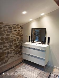 a bathroom with a sink and a tv on a wall at Maison entière au Centre de Villeneuve d'Olmes in Villeneuve dʼOlmes