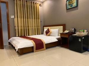 una camera con letto e telefono di Golden Hotel a Vung Tau