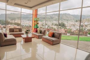 a lobby with chairs and a view of a city at Hotel Ambato in Ambato