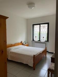 una camera con un grande letto e una finestra di Casa Maria-Appartamento in Villa a Ispra