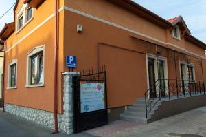 a orange building with a sign in front of it at Harmónia Apartmanház in Eger