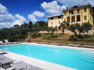a villa with a swimming pool in front of a building at Appartamento Bella Vista in Assisi