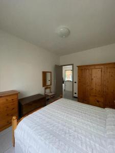 1 dormitorio con 1 cama blanca grande y armarios de madera en Casa Maria-Appartamento in Villa, en Ispra