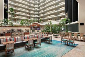 a restaurant with tables and chairs and a large building at Embassy Suites by Hilton San Juan - Hotel & Casino in San Juan