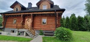 una casa de madera con una escalera delante de ella en Dom za 7 górami en Kazimierz Dolny