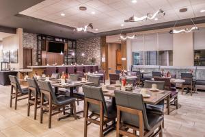 a restaurant with tables and chairs and a bar at Hilton Garden Inn Salt Lake City Downtown in Salt Lake City