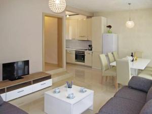 a living room with a couch and a tv and a table at 4 bedroom apartment with 3 bathrooms and private parking - Apartments Orange in Zadar
