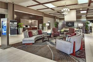 a lobby with couches and chairs on a rug at Hilton Sacramento Arden West in Sacramento