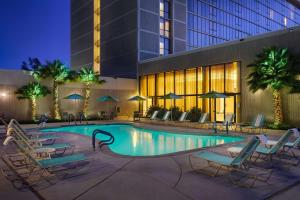 einen Pool mit Liegestühlen und ein Hotel in der Unterkunft Hilton Sacramento Arden West in Sacramento
