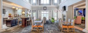 a living room with a kitchen and a table with chairs at Homewood Suites by Hilton Olmsted Village in Pinehurst