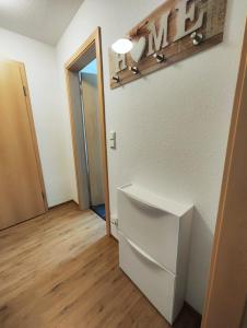 a room with a white refrigerator and a door at private Ferienwohnung Senftenberg in Sedlitz