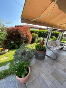 un patio con vasi di piante e panca di Casa Maria-Appartamento in Villa a Ispra