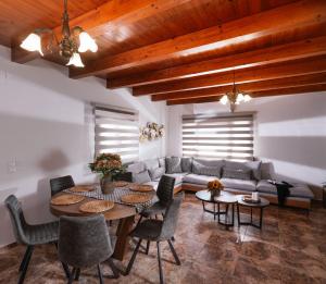 - un salon avec un canapé, une table et des chaises dans l'établissement SandShine Luxury Villa, à Kalamaki