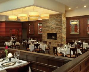 a restaurant with tables and chairs and a fireplace at DoubleTree by Hilton Collinsville/St.Louis in Collinsville