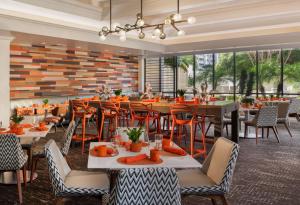 a restaurant with tables and chairs and a large window at Hilton St. Petersburg Bayfront in St. Petersburg