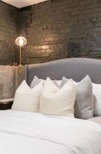 a bed with white pillows and a brick wall at Studio9Forty in Atlanta