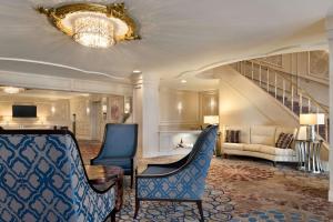 a lobby with blue chairs and a table and stairs at Hilton St. Louis Frontenac in Frontenac