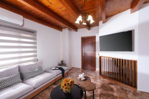 Il comprend un salon doté d'un canapé et d'une télévision à écran plat. dans l'établissement SandShine Luxury Villa, à Kalamaki