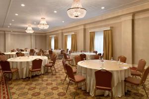 een feestzaal met witte tafels en stoelen en kroonluchters bij Hilton St. Louis Frontenac in Frontenac