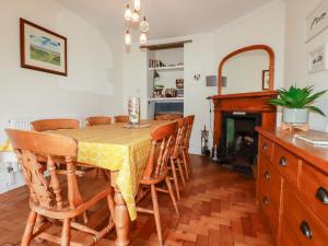 a dining room with a table and chairs and a fireplace at Trevethen Cottage in Newquay