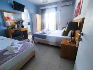 una camera d'albergo con 2 letti e una scrivania con un computer di Villa Riviera a Stavros
