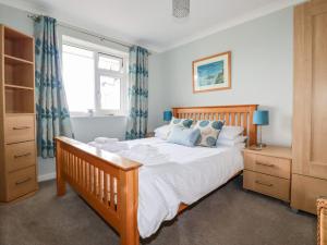 a bedroom with a large bed and a window at An Kres in Mevagissey