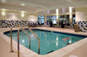 a large swimming pool in a hotel lobby at Hilton Garden Inn St. Louis Airport in Berkeley
