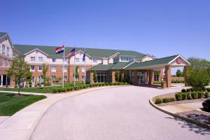 a large building with a driveway in front of it at Hilton Garden Inn St. Louis/O'Fallon in O'Fallon