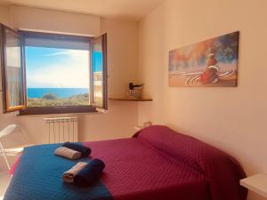 um quarto com uma cama e uma grande janela em Voce Del Mare - sea view- Alghero Airport em Alghero