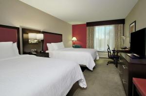 a hotel room with two beds and a flat screen tv at Hilton Garden Inn Sonoma County Airport in Santa Rosa