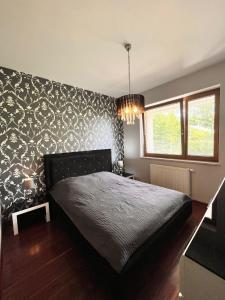 グディニャにあるAltoria Apartamentyのベッドルーム1室(白黒の壁紙のベッド1台付)