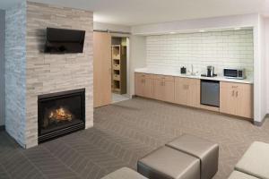 a living room with a fireplace and a tv at Hilton Garden Inn Sioux City Riverfront in Sioux City