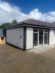 a white and black building with a garage at St Columbs House in Buncrana