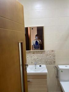 a man taking a picture of a bathroom mirror at Appartement en m'diq centre ville près de la plage in M'diq