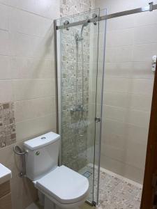 a bathroom with a toilet and a glass shower at Appartement en m'diq centre ville près de la plage in M'diq