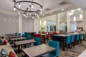 uma sala de jantar com mesas e cadeiras e um lustre em Hilton Garden Inn Tifton em Tifton