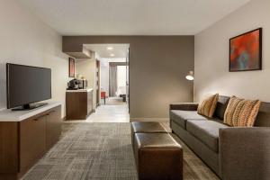 a living room with a couch and a flat screen tv at Hilton Garden Inn Tifton in Tifton