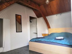 - une chambre avec un lit bleu dans l'établissement Le nid d'hirondelle, à Yzengremer