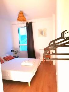 LA MAISON BLEUE في كويبيرون: غرفة صغيرة بها سرير ونافذة