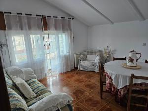 a living room with a table and a couch at As Rosas Apartamentos turísticos in Cambados
