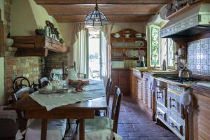 a kitchen with a wooden table and a stove at La Criolda Charming Villa in San Felice del Benaco