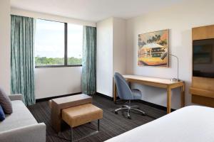 a hotel room with a desk and a bed at Embassy Suites by Hilton Tampa Airport Westshore in Tampa