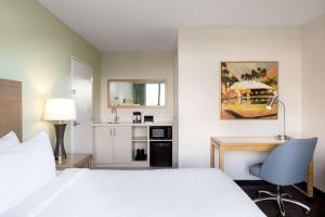 Habitación de hotel con cama y escritorio en Embassy Suites by Hilton Tampa Airport Westshore en Tampa