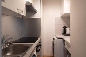 a small kitchen with a sink and a microwave at Calm and bright cocoon in Paris